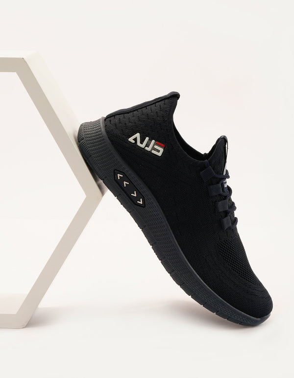 A black running sneaker with lace-up closure, featuring a textured upper and a flat sole.